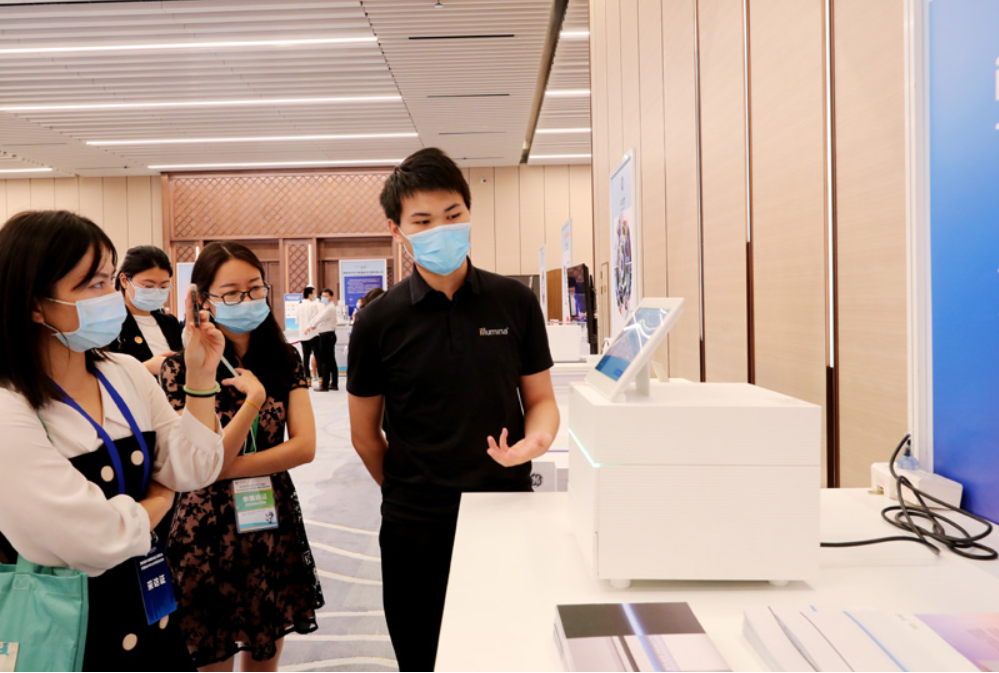 第四屆進(jìn)博會(huì)食品及農(nóng)產(chǎn)品展區(qū)、醫(yī)療器械及醫(yī)藥保健展區(qū)展前供需對(duì)接會(huì)的工作人員在介紹一臺(tái)測(cè)序儀展品